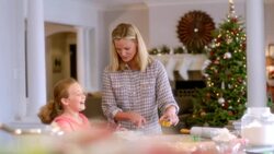 Mother and daughter press Christmas cookie-cutter shapes into cookie dough (dolly-shot) Stock Footage
