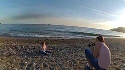 Mother taking a picture on the beach of her daughter Stock Footage