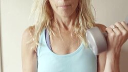 A mature woman does curls in her home gym. Stock Footage