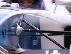 Close up pan from race car driver's face to tire being changed by pit crew Stock Footage