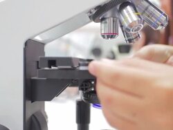 Dolly shot of Student using a microscope Stock Footage