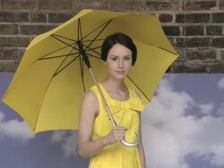 Young woman with umbrella, camera zooms out and she spins umbrella Stock Footage