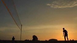 silhouette of volleyball players on the beach at sunset Stock Footage