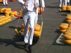 Men carrying large cheese rounds in historical cheese market, Alkmaar, Holland Stock Footage