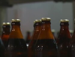 CU PAN Shot of brown glass beer bottles moving along conveyor / Wau, Western Bahr el Ghazal, Sudan  Stock Footage
