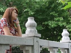 Young woman talking on a smartphone at a landing Stock Footage