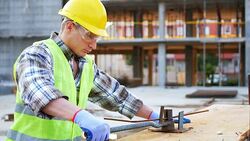 Blue collar worker on construction site, banding armature Stock Footage