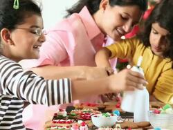 MS Mother and Two Daughters Decorating Gingerbread Cookies for Christmas / Richmond, Virginia, United States Stock Footage