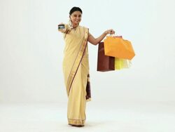 Portrait of a south Indian woman showing shopping bag and credit card  Stock Footage