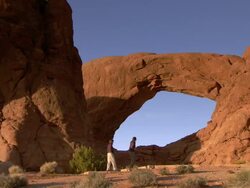 Tourists walking in front of South Window Arch at golden hour - wide Stock Footage