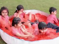 Group of kids playing holi festival in a lawn  Stock Footage