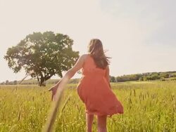 SLO MO Joyful girl running barefoot in the grass Stock Footage