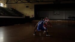 An assist by an offensive team player helps a teammate score a slam dunk in a two-on-two basketball game. Stock Footage