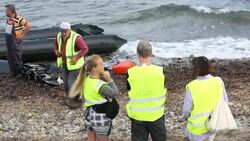 Syrian migrants fleeing the war and escaping to Europe, landing on the Greek island of Lesvos on the north coast at Efthalou and helped ashore by volunteers. Up to 4,000 migrants a day are landing on the island and overwhelming the authorities. They are tr Stock Footage