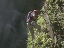 Man abseiling by waterfall Stock Footage