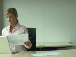 Wmoan looking at papers and laptop; UK Stock Footage