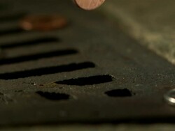 Money Down the Drain - High speed English coin, 1p falling in to road drain, low angle 5 BCU Stock Footage