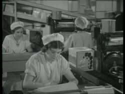 Biscuit boxes on conveyor are counted by an photoelectric cell, UK  1939 Stock Footage
