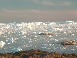 WS T/L View of icebergs moving in icy water at sunset / Ilulissat, Greenland Stock Footage