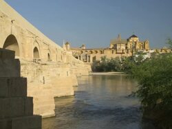 WS Roman bridge, Guadalquivir river and Cathedral-Mosque, aka Great Mosque (mezquita) and Cathedral in background Stock Footage