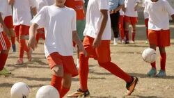 Brazilian flag waves over youth league soccer practice Stock Footage