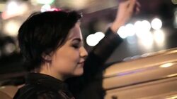young woman riding in classic convertible grooves to the radio and waves hand in the wind Stock Footage