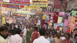 Signs hang over a crowded outdoor market in India. Stock Footage
