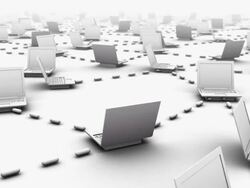 Camera twists away from close up of laptop to reveal innumerous connected laptops Stock Footage