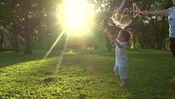 HD:Little boy in the sunset catches soap bubbles. Stock Footage