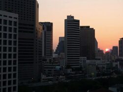 Setting Sun at between Buildings of Rama IV Road, Bangkok, Thailand Stock Footage