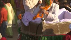 Monks pass a necklace of flowers to a dignitary that rides an elephant during India's Diwali celebration. Stock Footage