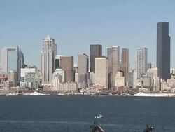 Extreme Long Shot static - A ship cruises over the ocean near a city's skyline / Seattle, Washington, USA Stock Footage