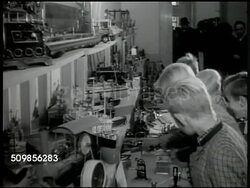 1946: AMERICAN ZONE, GERMANY: EXPORT SHOW: Boys indoors looking at three shelves of displayed toys, models, one boy reaching up to touch encased item on top shelf. Instructional Video