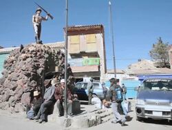 WS View of people sitting under statue on road with vehicles moving at Potosi / Potosi, Bolivia Stock Footage