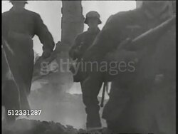 1939: NAZI WWII PROPAGANDA: Nazi Infantry soldiers walking through burned rubble of house. Children, boys walking on bombed town sidewalk carrying bundles, smoke BG. Refugees, displaced persons, possibly orphans. Instructional Video