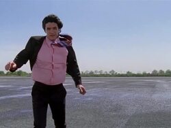 Low angle medium shot businessman walking against the wind in empty lot Stock Footage