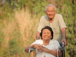 Senior man pushing her disabled wife on wheelchair Stock Footage