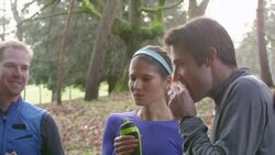 MS Group of runners talking while drinking water and eating energy bars after run in park Stock Footage
