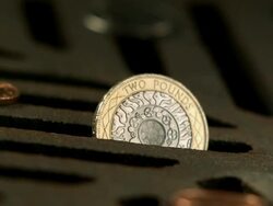 Money Down the Drain - High speed English two pound coin falling on and in to road drain, low angle, BCU Stock Footage