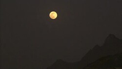 A full moon glows over a mountain range. Stock Footage