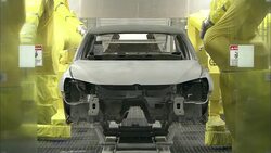 A conveyor moves an auto body through a painting chamber. Stock Footage