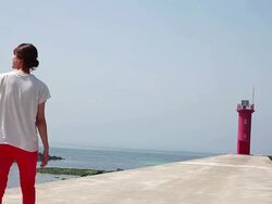 WS View of Father carrying son on shoulders and mother walking towards lighthouse / Jeju, Jeju-do, South Korea Stock Footage