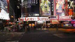 Traffic and pedestrians move past large neon signs and billboards along 42nd Street and Times Square in New York City at night. Stock Footage