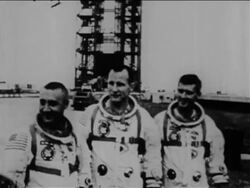 B/W 1967 three astronauts in spacesuits posing outdoors with launch tower in background / Apollo 1 Stock Footage