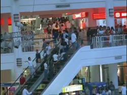 T/L MWA high angle, people moving up and down escalators at busy shopping mall, children playing in play area, makati commercial centre, manila, Philippines Stock Footage