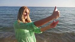 Beautiful girl taking selfie on beach Stock Footage