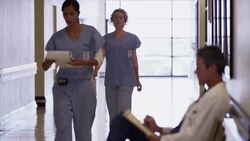 Nurses walking past doctor in hospital corridor Stock Footage
