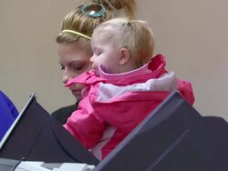 MS Shot of young mother holding her daughter in presidential election at union hall / Toledo, Ohio, United States Stock Footage