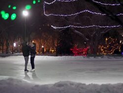Caucasian couple skates together on a winter night. Stock Footage