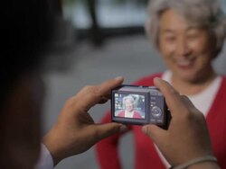 CU R/F Elderly woman having her photo taken by man / China Stock Footage